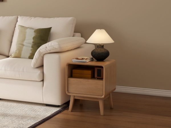 A tidy bedside table at dawn with a warm cup, an open notebook, and soft natural light